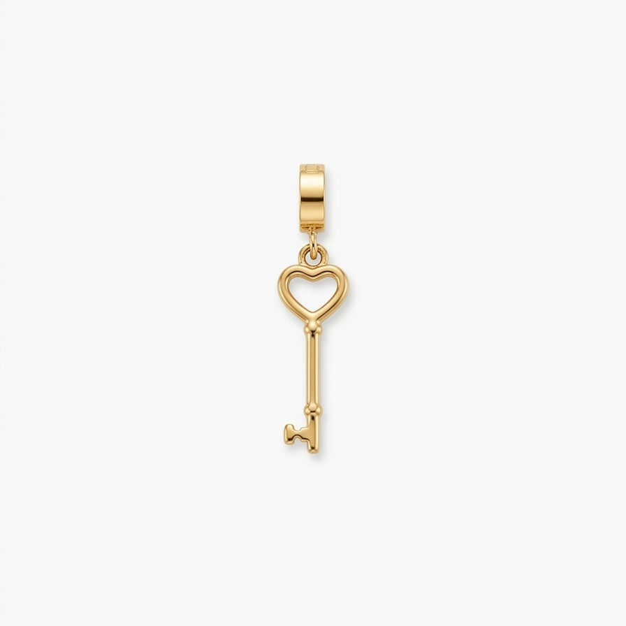 A gold key-shaped pendant charm with a heart-shaped key head, shown on a clean white background.