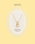Gold necklace with a heart pendant on a yellow background